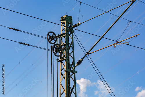 Several cables, wires and gears on a pole for overhead lines for railroads