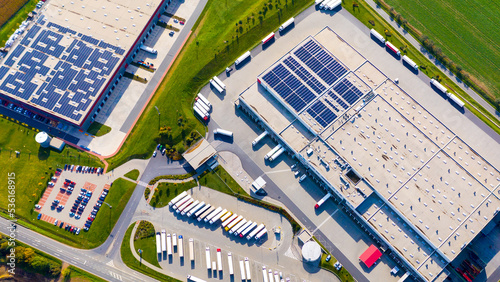 Industry with low carbon footprint. Industrial warehouses with solar panels on the roof. Technology park and factories  from above.