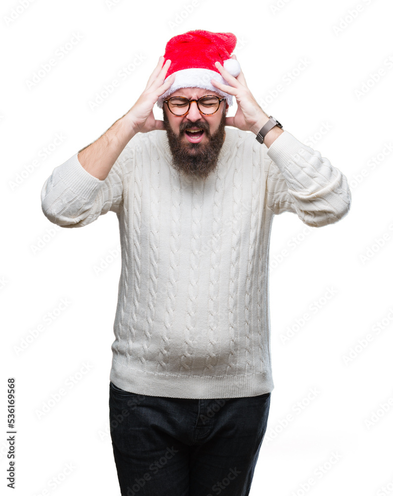 Young caucasian man wearing christmas hat and glasses over isolated background suffering from headache desperate and stressed because pain and migraine. Hands on head. Young caucasian man wearing christmas hat and glasses over isolated background suffering from headache desperate and stressed because pain and migraine. Hands on head.