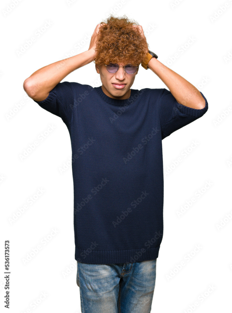 Young handsome man with afro wearing glasses suffering from headache desperate and stressed because pain and migraine. Hands on head. Young handsome man with afro wearing glasses suffering from headache desperate and stressed because pain and migraine. Hands on head.