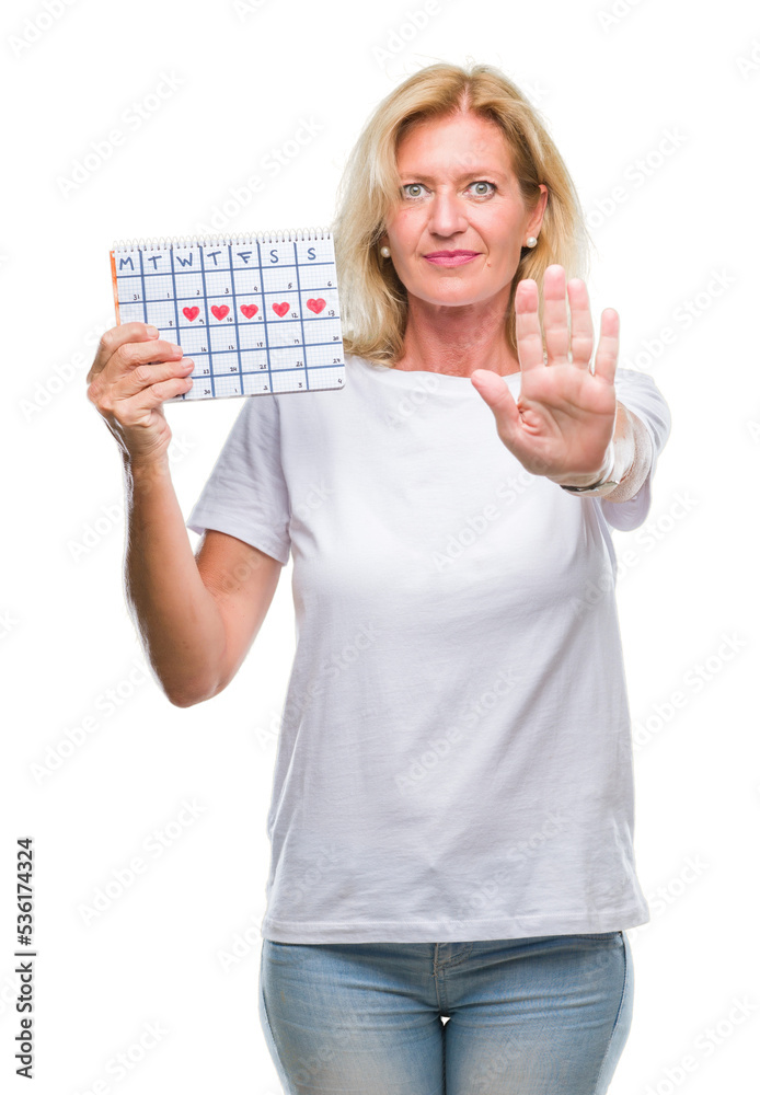 Obraz premium Middle age blonde woman holding menstruation calendar ver isolated background with open hand doing stop sign with serious and confident expression, defense gesture