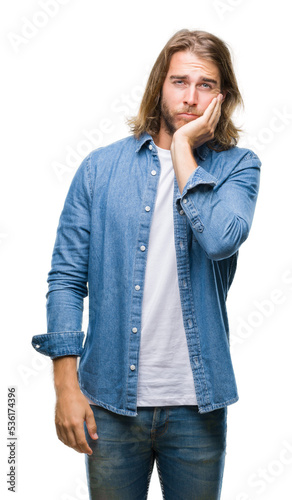 Young handsome man with long hair over isolated background thinking looking tired and bored with depression problems with crossed arms.