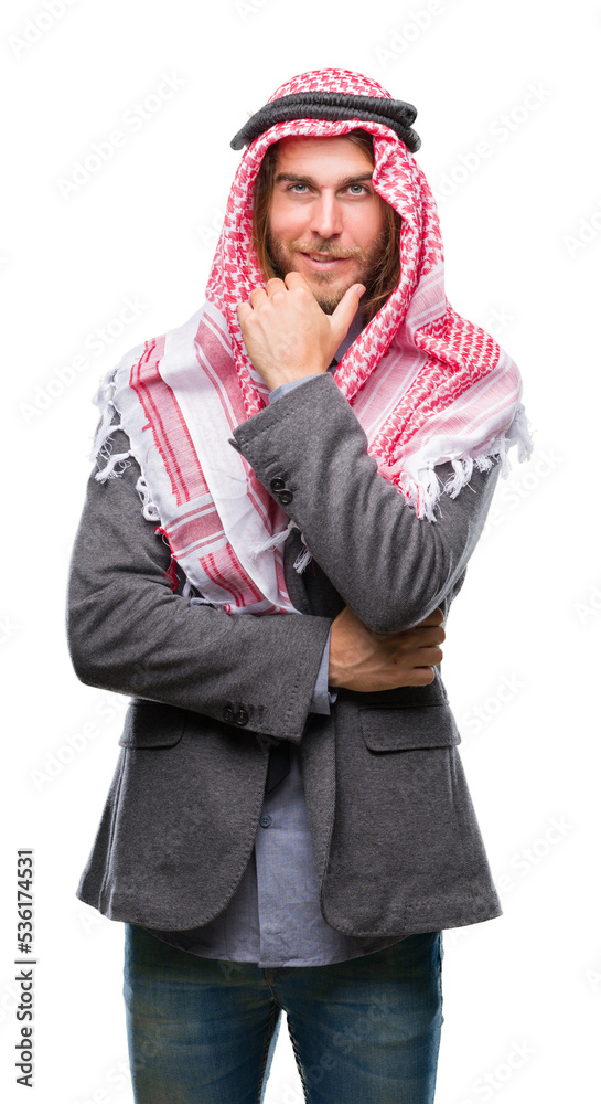 Young handsome arabian man with long hair wearing keffiyeh over isolated background looking confident at the camera with smile with crossed arms and hand raised on chin. Thinking positive. Young handsome arabian man with long hair wearing keffiyeh over isolated background looking confident at the camera with smile with crossed arms and hand raised on chin. Thinking positive.
