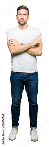 Handsome man wearing casual white t-shirt Pointing with hand finger to the side showing advertisement, serious and calm face