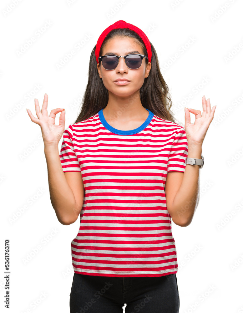 Young beautiful arab woman wearing sunglasses over isolated background relax and smiling with eyes closed doing meditation gesture with fingers. Yoga concept.