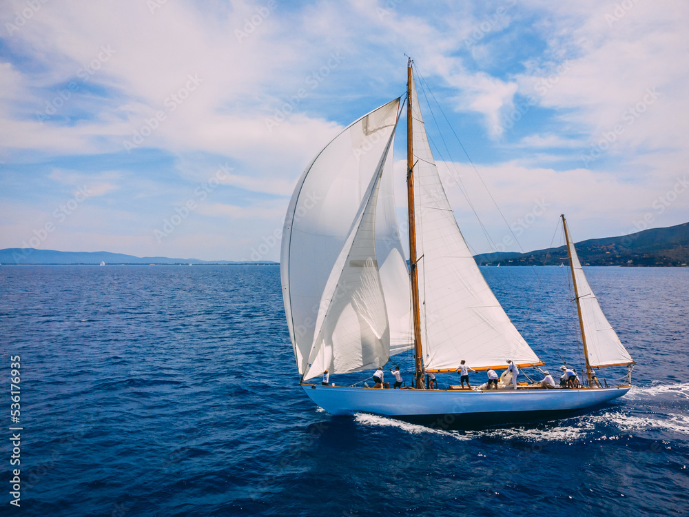 Classic wooden yacht sailing with crew in regatta in the Mediterranean sea.
