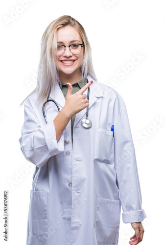 Young blonde doctor woman over isolated background cheerful with a smile of face pointing with hand and finger up to the side with happy and natural expression on face looking at the camera.