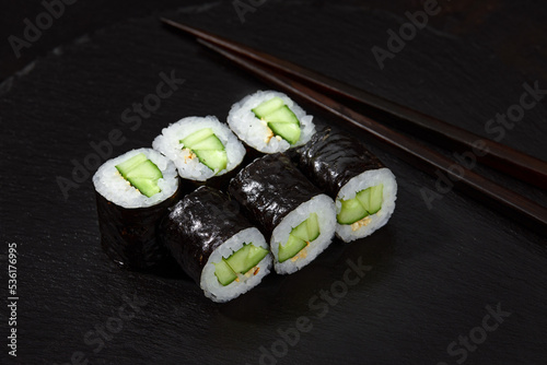 Sushi Maki rolls cucumber. Fresh hosomaki pieces with rice and nori. Close Up of delicious japanese food with sushi roll. photo