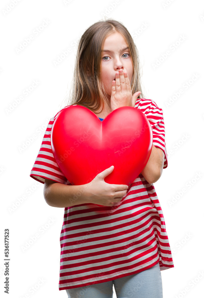 Young beautiful girl holding red heart over isolated background cover mouth with hand shocked with shame for mistake, expression of fear, scared in silence, secret concept Young beautiful girl holding red heart over isolated background cover mouth with hand shocked with shame for mistake, expression of fear, scared in silence, secret concept