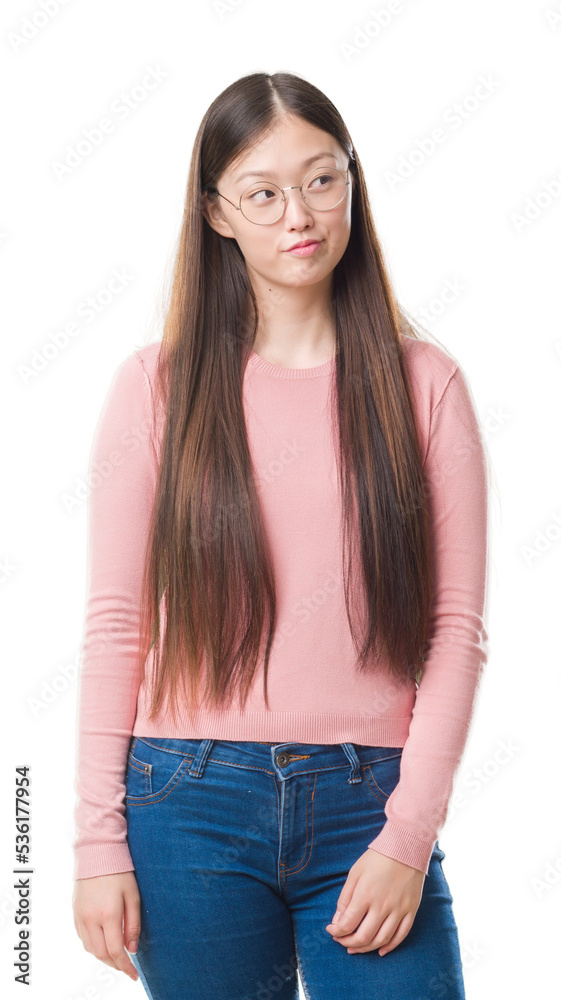 Obraz premium Young Chinese woman over isolated background wearing glasses smiling looking side and staring away thinking.