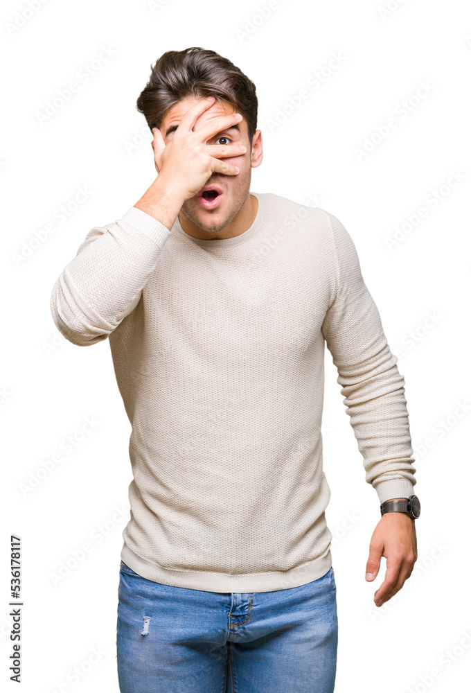 Young handsome man over isolated background peeking in shock covering face and eyes with hand, looking through fingers with embarrassed expression. Young handsome man over isolated background peeking in shock covering face and eyes with hand, looking through fingers with embarrassed expression.