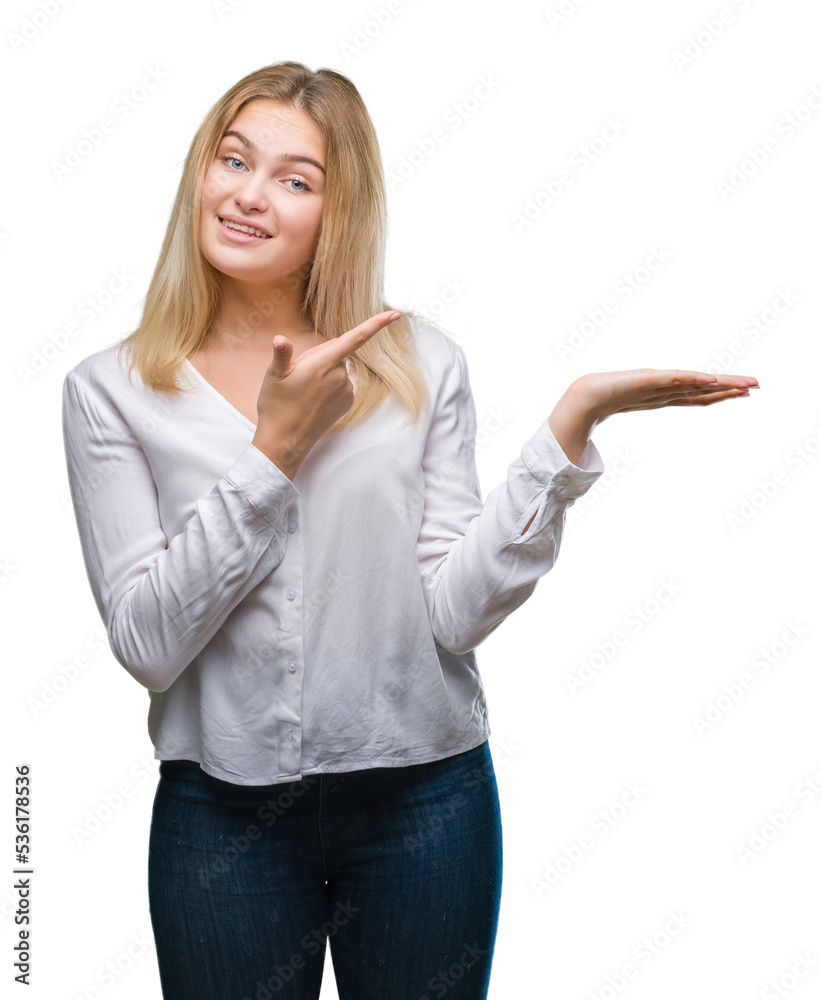 Young caucasian woman over isolated background amazed and smiling to the camera while presenting with hand and pointing with finger. Young caucasian woman over isolated background amazed and smiling to the camera while presenting with hand and pointing with finger.