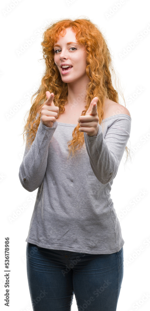 Young redhead woman pointing fingers to camera with happy and funny face. Good energy and vibes. Young redhead woman pointing fingers to camera with happy and funny face. Good energy and vibes.