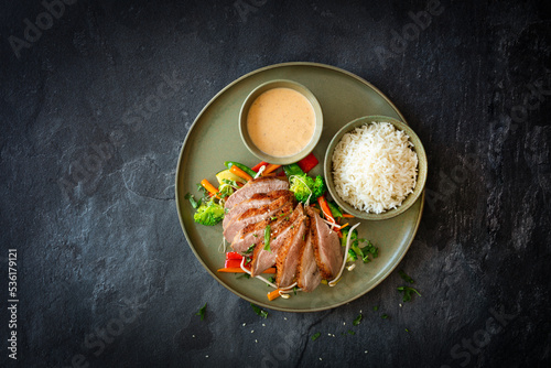 Entenbrust mit roter Massaman-Currysauce, Reis und Wokgemüse photo