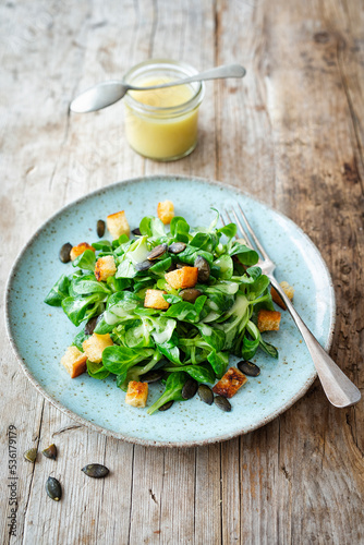 Feldsalat mit Kartoffel-Knoblauch-Dressing, gerösteten Kürbiskernen und Croûtons