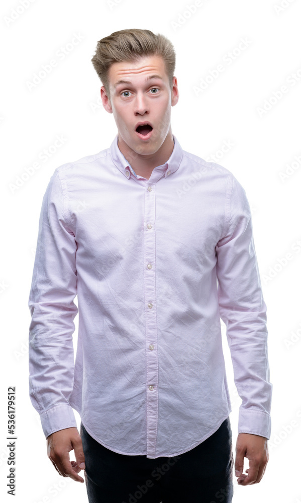 Young handsome blond man scared in shock with a surprise face, afraid and excited with fear expression