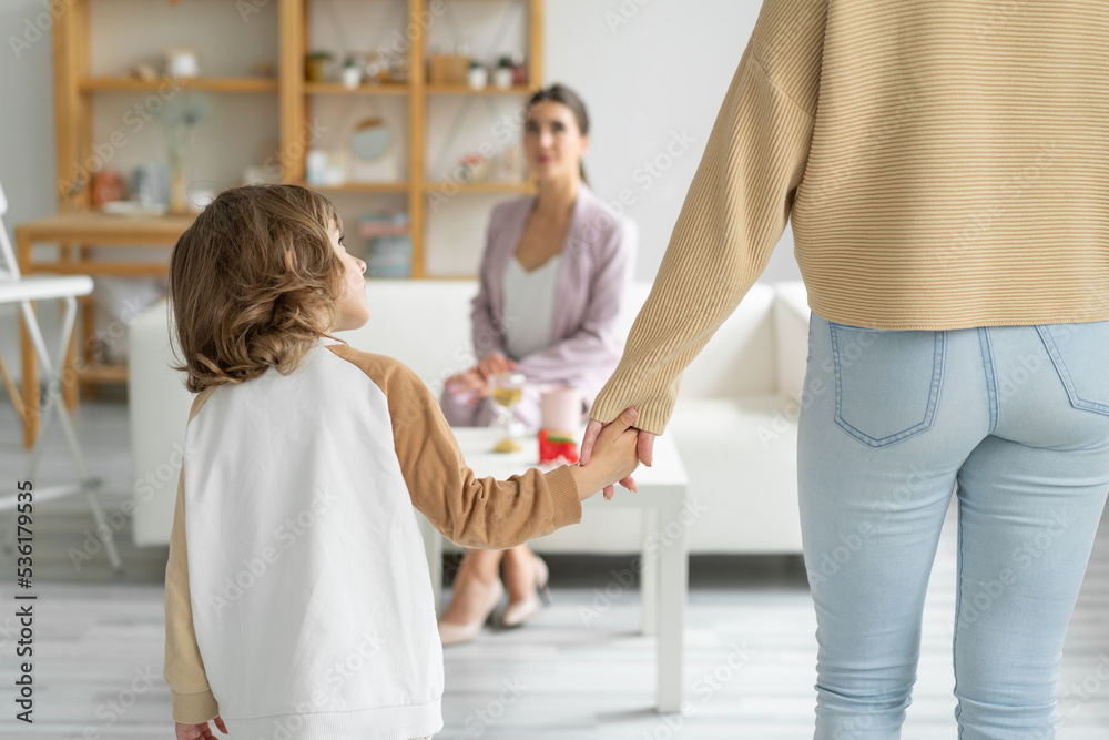 Obraz premium Concept of a happy healthy relationship between children and parents. Go to a family psychologist. Mom holds the hand of her not quite year old son.