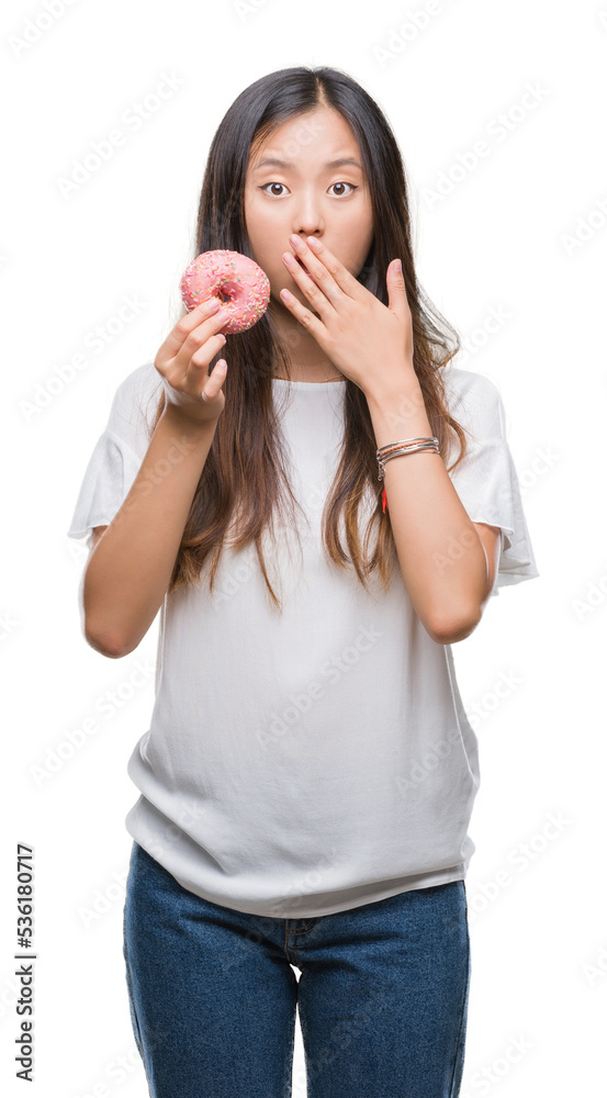 Young asian woman eating donut over isolated background cover mouth with hand shocked with shame for mistake, expression of fear, scared in silence, secret concept Young asian woman eating donut over isolated background cover mouth with hand shocked with shame for mistake, expression of fear, scared in silence, secret concept