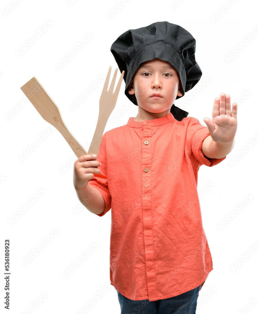 Dark haired little child wearing chef uniform with open hand doing stop sign with serious and confident expression, defense gesture Dark haired little child wearing chef uniform with open hand doing stop sign with serious and confident expression, defense gesture