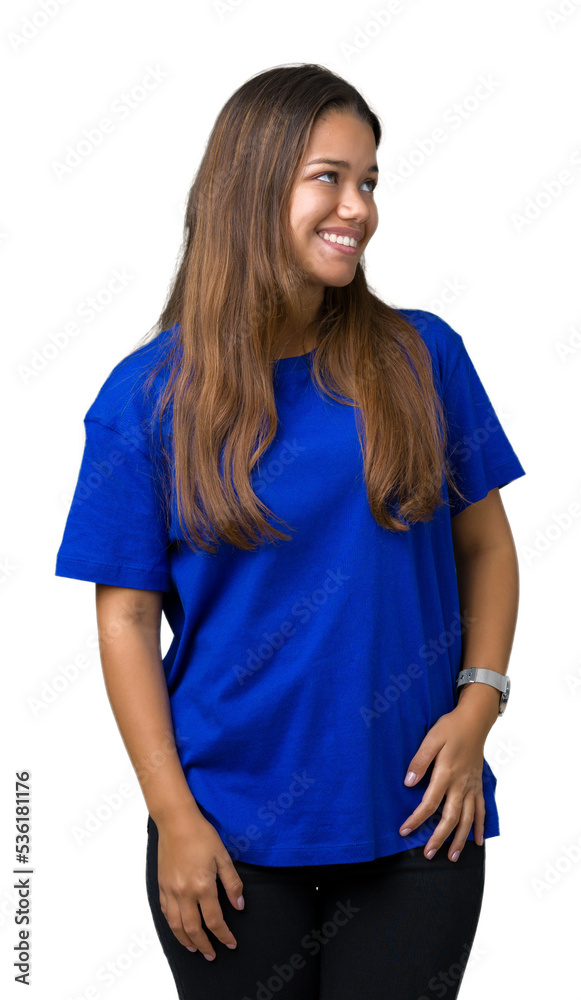 Young beautiful brunette woman wearing blue t-shirt over isolated background looking away to side with smile on face, natural expression. Laughing confident.