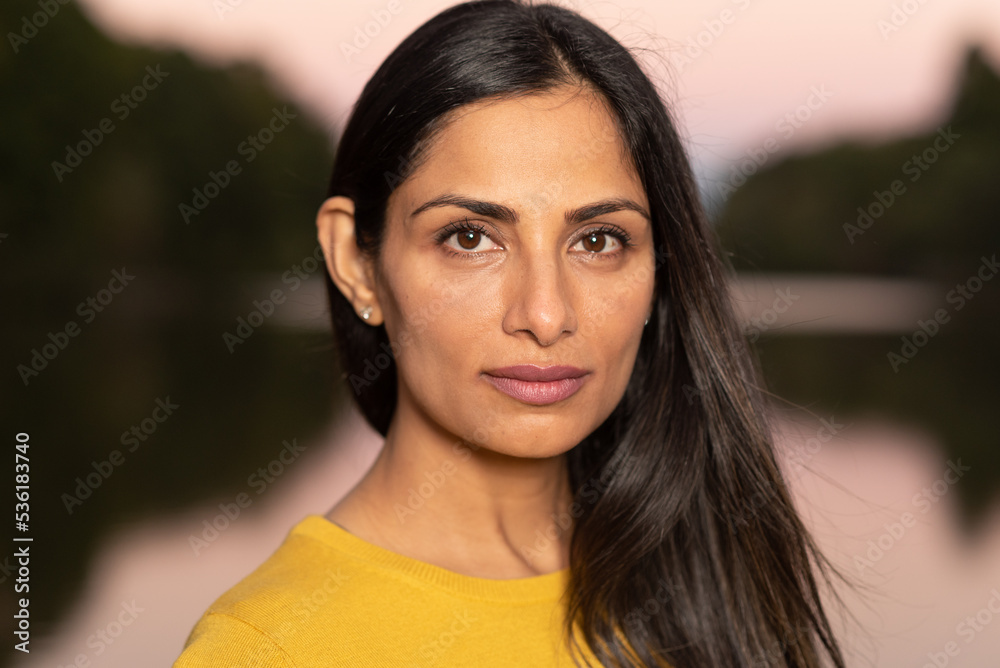 Beautiful Asian Indian woman in yellow sweater by a lake. Beautiful Asian Indian woman in yellow sweater by a lake.
