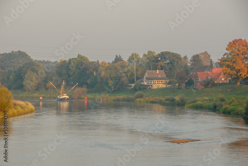 Weser bei Drakenburg mit Aalschokker, Buhnen und Sandbank im abendlichen Dunst photo