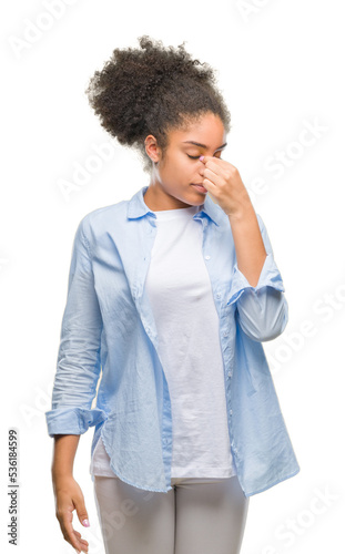 Young afro american woman over isolated background tired rubbing nose and eyes feeling fatigue and headache. Stress and frustration concept.