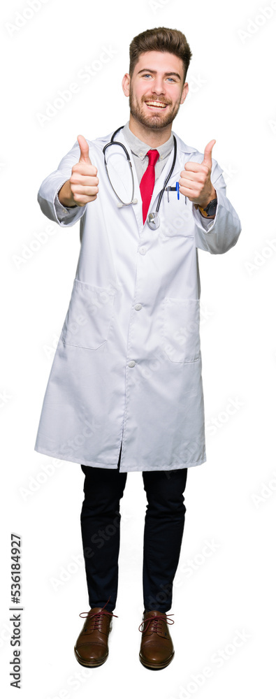 Young handsome doctor man wearing medical coat approving doing positive gesture with hand, thumbs up smiling and happy for success. Looking at the camera, winner gesture. Young handsome doctor man wearing medical coat approving doing positive gesture with hand, thumbs up smiling and happy for success. Looking at the camera, winner gesture.
