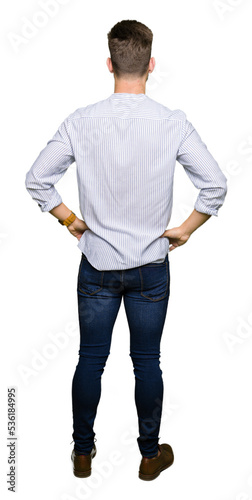 Young handsome man standing backwards looking away with arms on body photo