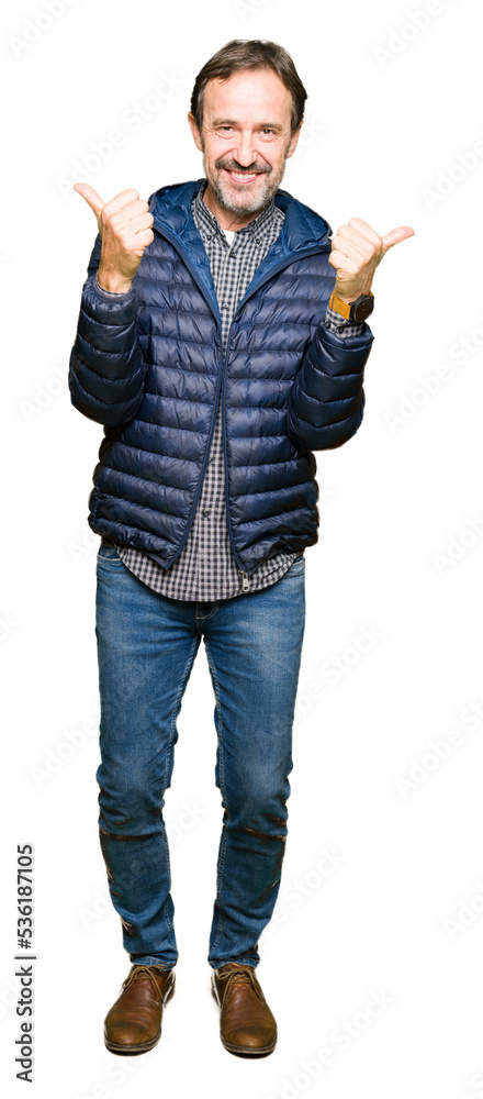 Middle age handsome man wearing winter coat success sign doing positive gesture with hand, thumbs up smiling and happy. Looking at the camera with cheerful expression, winner gesture. Middle age handsome man wearing winter coat success sign doing positive gesture with hand, thumbs up smiling and happy. Looking at the camera with cheerful expression, winner gesture.