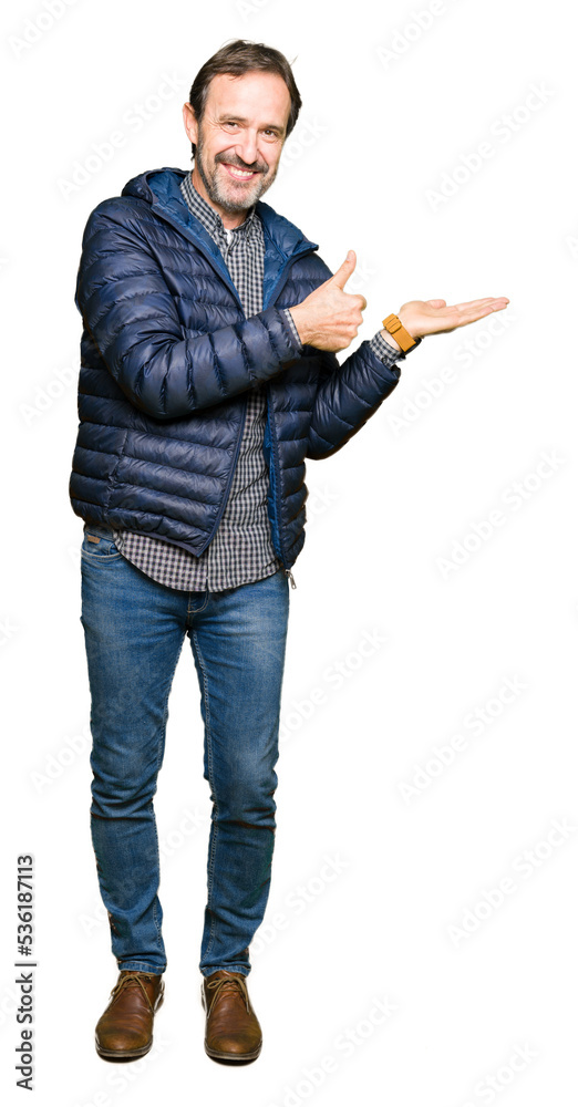 Middle age handsome man wearing winter coat Showing palm hand and doing ok gesture with thumbs up, smiling happy and cheerful Middle age handsome man wearing winter coat Showing palm hand and doing ok gesture with thumbs up, smiling happy and cheerful