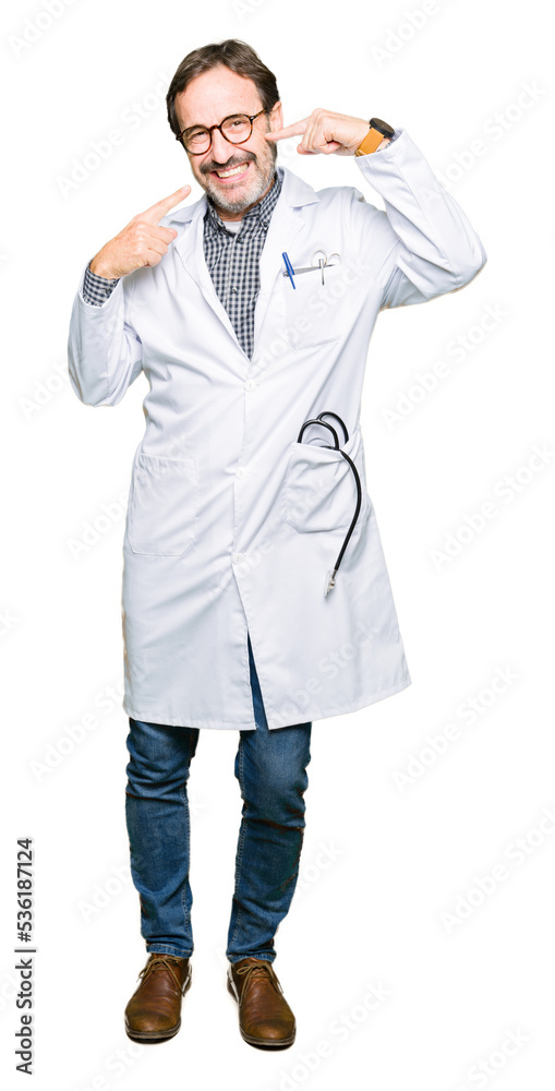 Middle age doctor men wearing medical coat smiling confident showing and pointing with fingers teeth and mouth. Health concept.