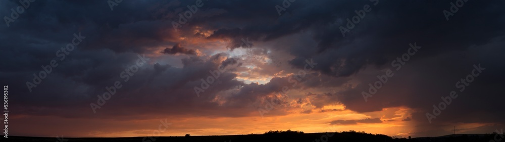 Landscape at sunset. Tragic gloomy sky. Panorama. Crimson twilight.