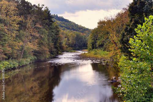Fototapeta Naklejka Na Ścianę i Meble -  The Williams River slicing through the picturesque New England countryside while providing reflections of its surroundings in early autumn. 