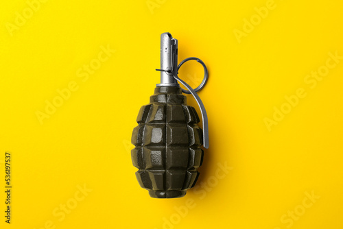 Hand grenade on yellow background, top view