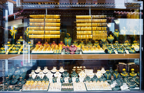 Glass windows of traditional Turkish jewelry stores with abundance of gold bracelets  rings  pendants and earrings on street in Konya city.