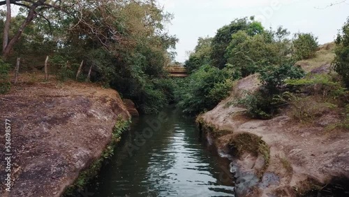 drone view of a natural water channel advancing with lots of trees and bushes - prado tolima colombia photo