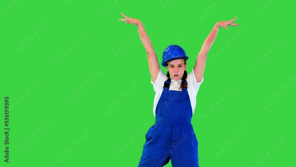 Young female construction worker dancing on a Green Screen, Chroma Key. Young female construction worker dancing on a Green Screen, Chroma Key.