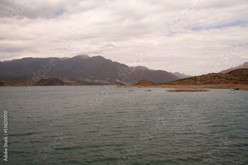 View of the reservoir in Potrerillos, Mendoza. The arid environment, turquoise glacier water lake and Andes mountains in the background.