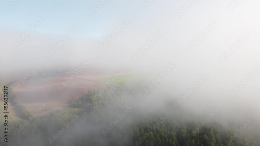 Mist fog clouds from above aerial view over seasonal autumn forest low morning sunlight Mist fog clouds from above aerial view over seasonal autumn forest low morning sunlight