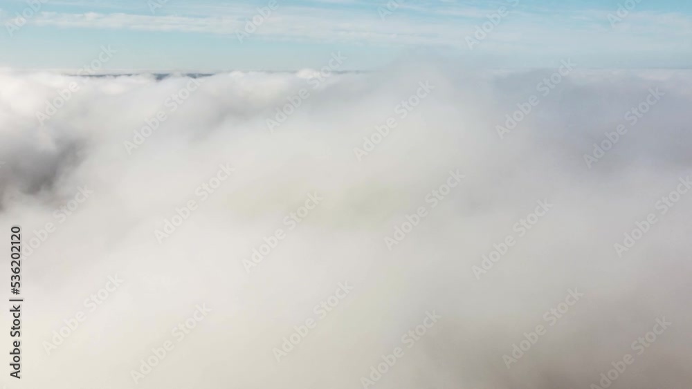 Mist fog clouds from above aerial view over seasonal autumn forest low morning sunlight