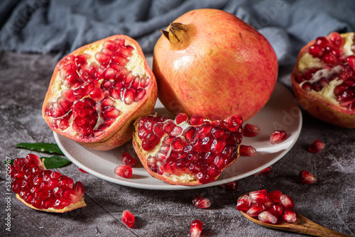 ripe pomegranate fruit with open pomegranate on table