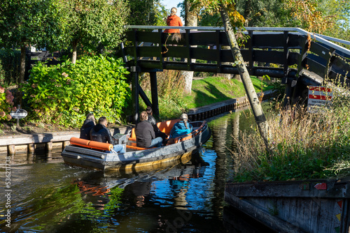 Giethoorn Netherlands Venice of the North people on a boat in the village center on the canals with bridge photo