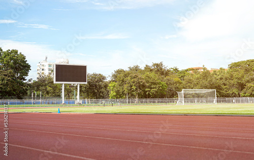 Scene of football field with scoreboard and bright blue sky.