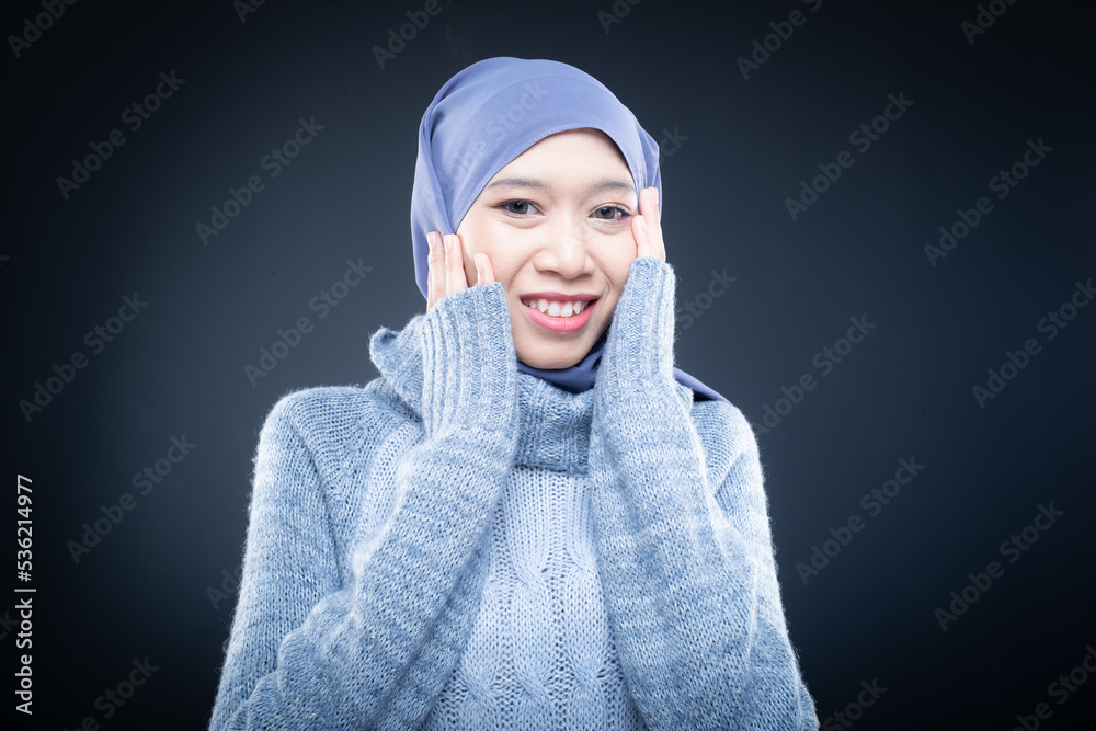 Portrait of a beautiful female model wearing hijab, a lifestyle apparel for Muslim women isolated on brown background. Idul Fitri and hijab fashion concept. Isolated on dark background Portrait of a beautiful female model wearing hijab, a lifestyle apparel for Muslim women isolated on brown background. Idul Fitri and hijab fashion concept. Isolated on dark background