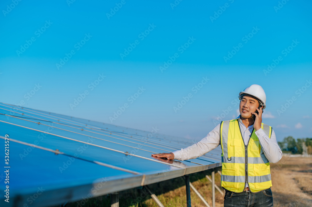 Young engineer use smartphone while working at solar farm Young engineer use smartphone while working at solar farm