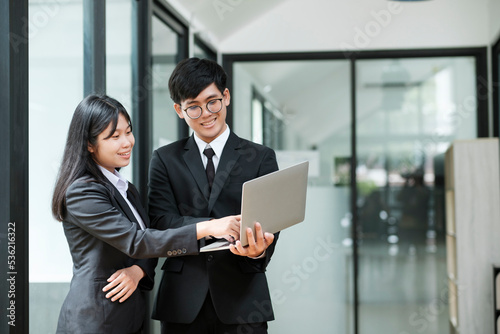 Two businesspeople talking and discussing while standing.