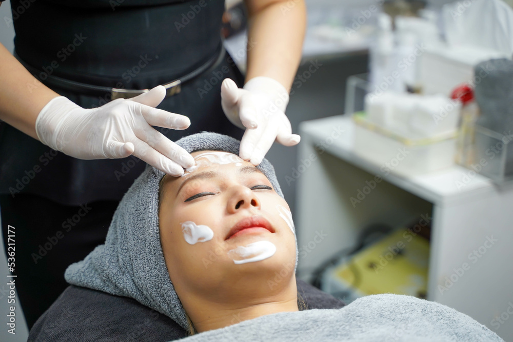 Young beauty woman in towel making facial massage with organic face scrub. Young beauty woman in towel making facial massage with organic face scrub.