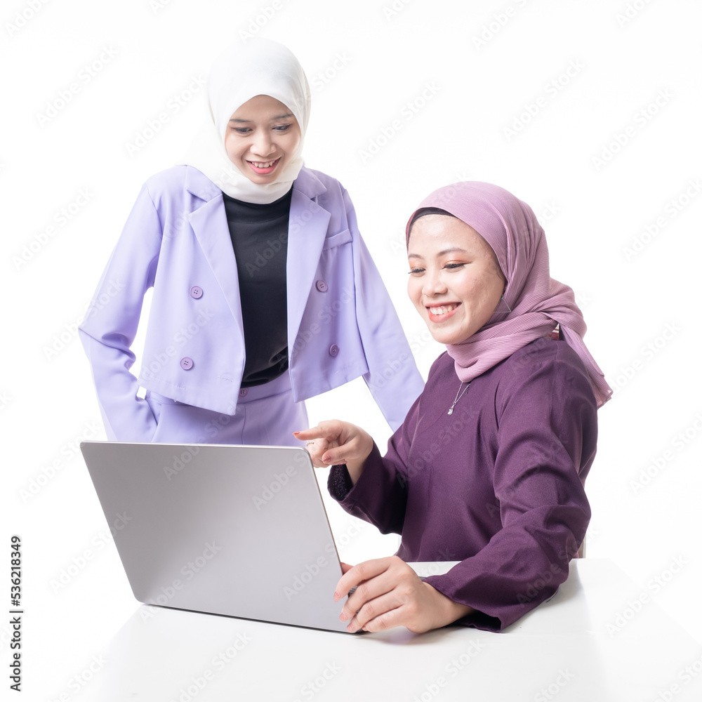 Muslim colleagues wearing hijab smiling and communicating at workplace. Teammates discussing about work in office. Friendly businesswomen discussing project ideas. Isolated on white background
