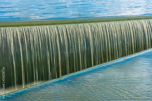 Water flowing in ditch inlet. Weir water stripes pattern,use for background and texture.